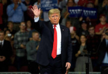 Trump’s Iran Retweet Sparks Global Tension A man in a suit waving to a cheering crowd at a political rally