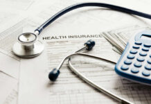 Stethoscope and calculator on health insurance documents
