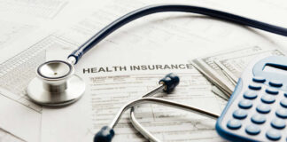 Stethoscope and calculator on health insurance documents