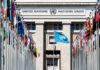 United Nations building with multiple international flags in front