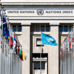 United Nations building with multiple international flags in front