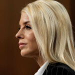 DOJ’s New Direction: Bondi AXES Biden Limits Profile view of a woman with blonde hair in business attire, displaying a serious expression