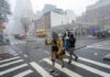 People crossing a snowy street in an urban area during a winter storm