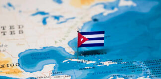 A small Cuban flag placed on a map highlighting Cuba in the Caribbean
