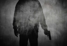 Silhouette of a person holding a gun against a textured background