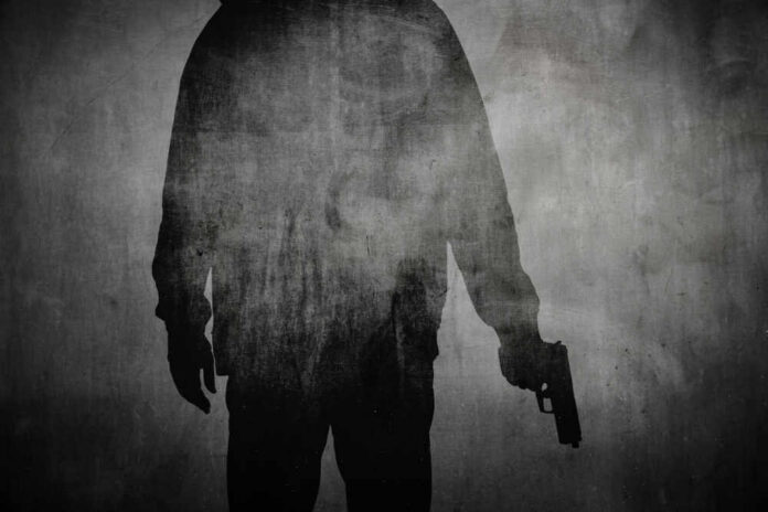 Silhouette of a person holding a gun against a textured background