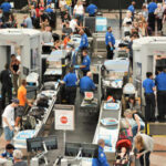 Busy airport security checkpoint with travelers and TSA agents