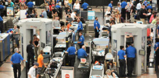 Busy airport security checkpoint with travelers and TSA agents