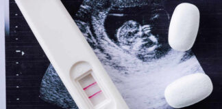 Pregnancy test next to an ultrasound image and two white tablets