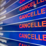Airport departure board showing multiple flights marked as cancelled