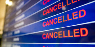 Airport departure board showing multiple flights marked as cancelled