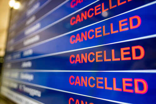 Airport departure board showing multiple flights marked as cancelled