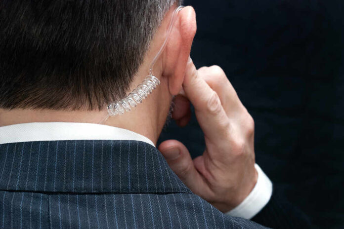 shutterstock_172646543.jpg Close-up of a man in a suit with an earpiece, indicating a security role