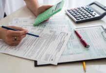Person calculating financial figures with documents and a calculator
