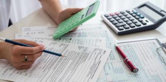 Person calculating financial figures with documents and a calculator