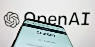 Close-up of a smartphone displaying the ChatGPT interface with the OpenAI logo in the background