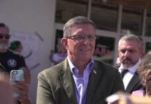 $1.2 Million Flynn Deal Stuns Washington A man in a blazer interacting with a crowd during a public event