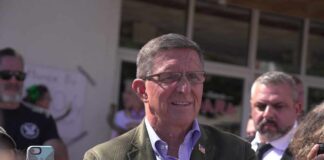A man in a blazer interacting with a crowd during a public event