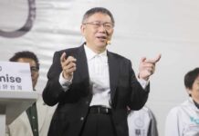A speaker gestures while addressing an audience at a political event