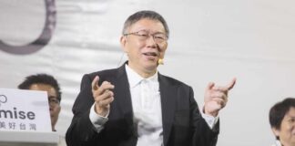 A speaker gestures while addressing an audience at a political event