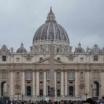 St. Peters Basilica in Vatican City with a cloudy sky and a large obelisk in the foreground