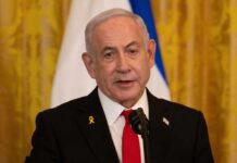 A government official speaking at a podium with a microphone