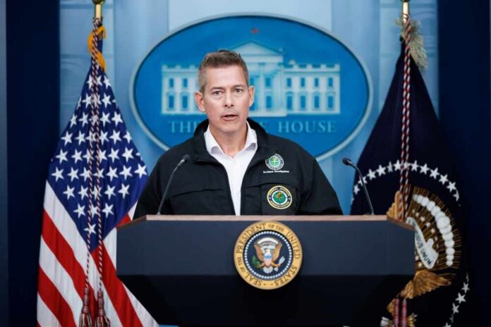 Government official speaking at a podium in front of the White House backdrop