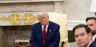 A group of political figures seated in a formal setting, with one individual looking contemplative