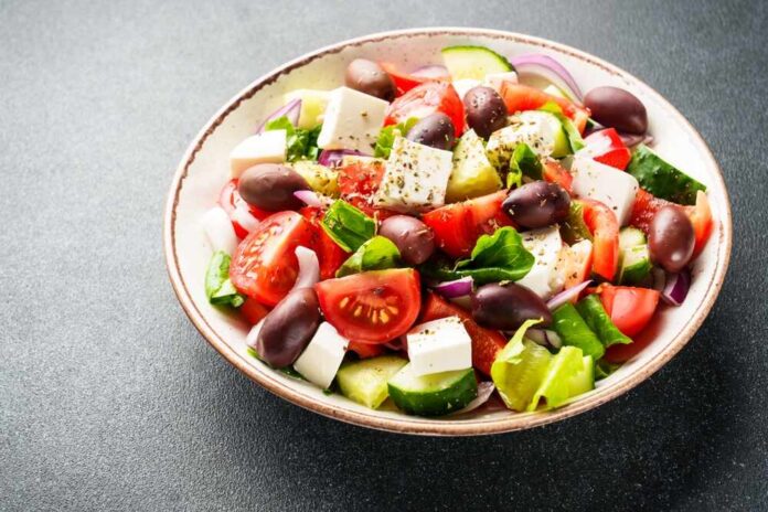 A vibrant salad with tomatoes, cucumbers, olives, and feta cheese