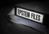 A black binder labeled 'Epstein Files' with papers and a pen beside it