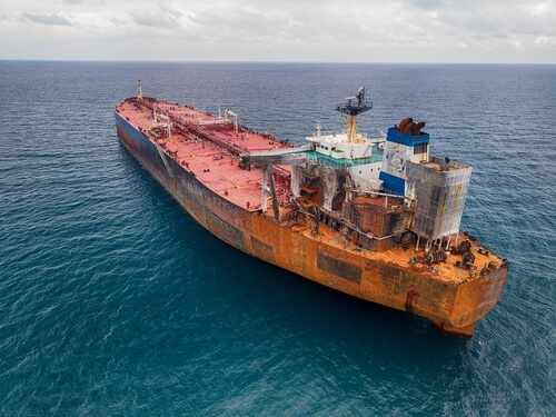 Aerial view of a large, rusty oil tanker in the ocean