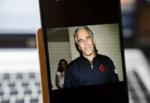 A man in casual attire smiling at the camera