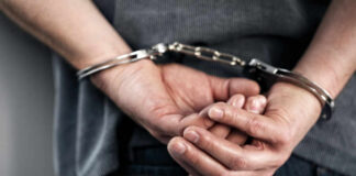 Hands cuffed behind the back, indicating arrest