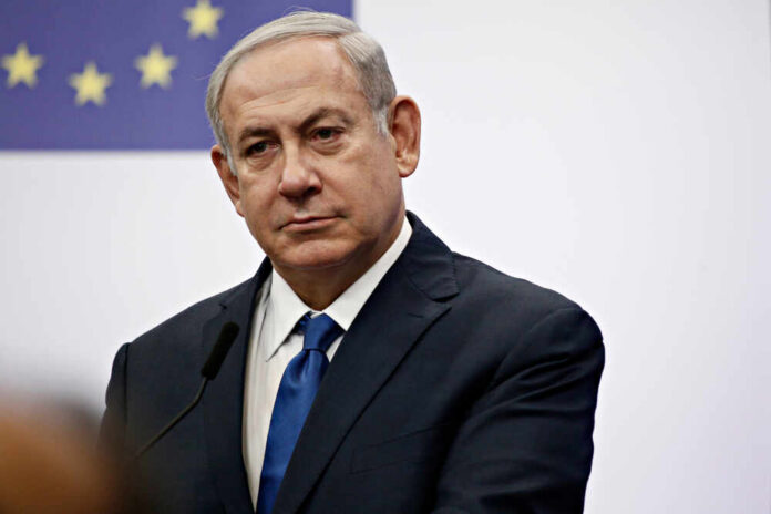 A serious-looking man in a suit at a press conference with a European flag in the background