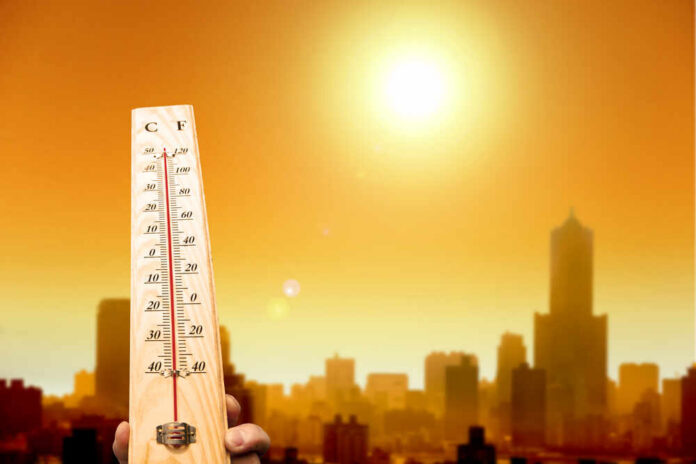 shutterstock_144222931.jpg A thermometer held against a sunset city skyline