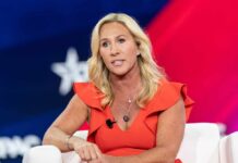 A woman in a red dress speaking at a conference