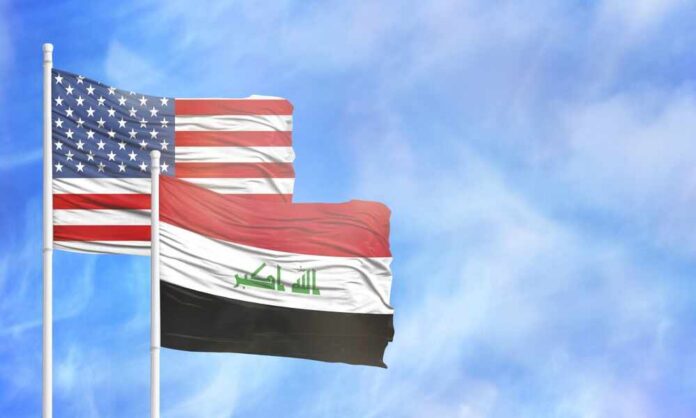 Flags of the United States and Iraq waving against a blue sky