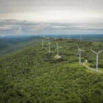 Aerial view of wind turbines on a green hillside