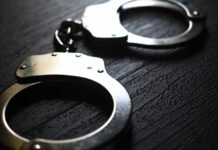 Close-up of metallic handcuffs on a textured surface