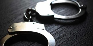 Close-up of metallic handcuffs on a textured surface