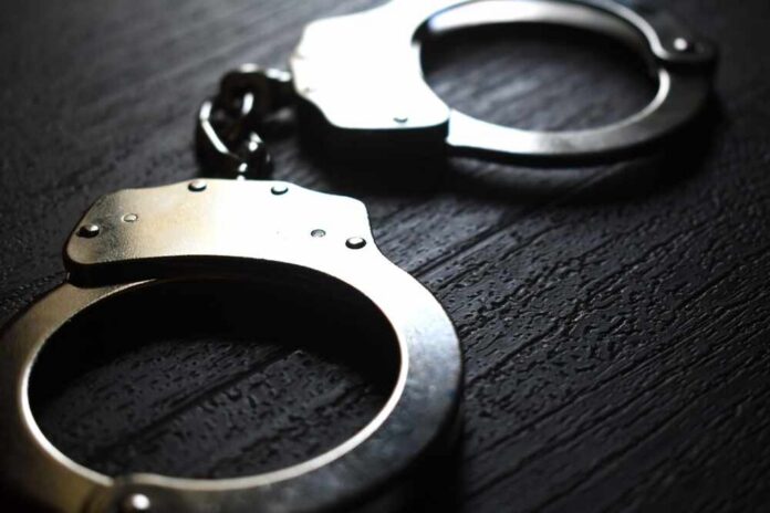 Close-up of metallic handcuffs on a textured surface