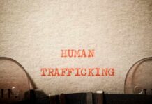 Typewritten text reading 'HUMAN TRAFFICKING' on paper