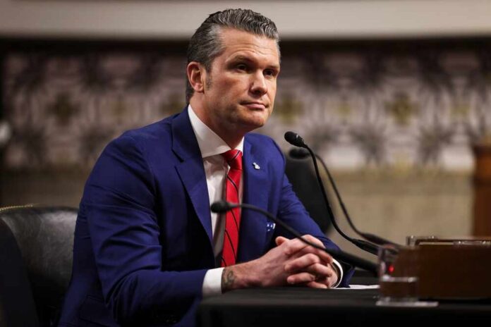 Man in a blue suit sitting at a table during a government hearing