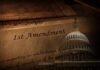 Close-up of the First Amendment text with the U.S. Capitol dome in the background