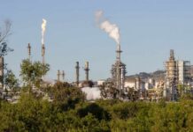 Industrial refinery with smoke stacks and visible flames