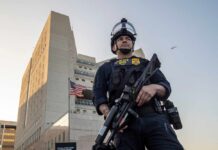 Abuse Epidemic: Detention Centers Under Fire Police officer in tactical gear standing in front of a building
