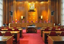 Generational Battle: Will Trump Reshape the Court Again? Interior view of a courtroom with wooden paneling and red seating