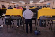 Massive Voting Machine Ban Plot Exposed! Individuals casting votes at a polling station with electronic voting machines
