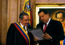 Cuba’s Fiery Outrage: Will U.S. Retaliate? Two officials examine a framed document during a ceremony