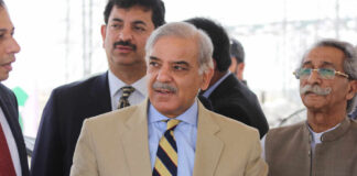 Group of men in formal attire engaged in conversation outdoors